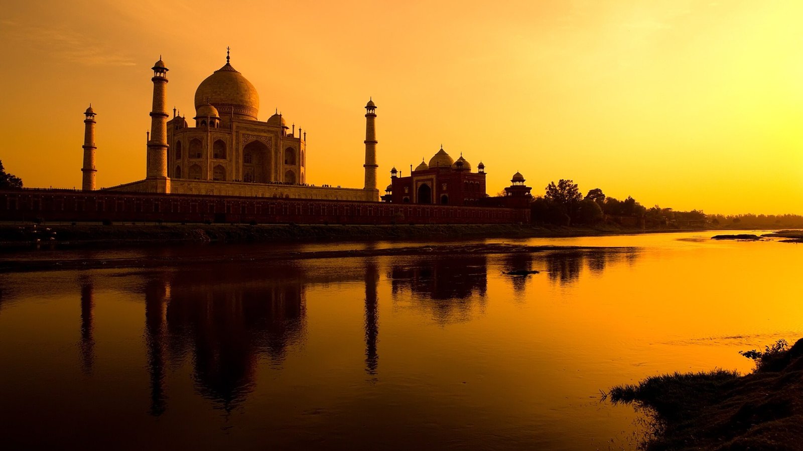 Taj Mahal refletido na água ao pôr do sol, Agra, Índia.